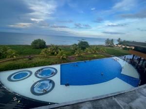 a large blue swimming pool with the ocean in the background at Seafront Residences Vacation Getaway in San Juan