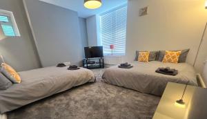 1 dormitorio con 2 camas y TV. en Spacious ground floor suite comfortably sleeps up to eight en Halifax