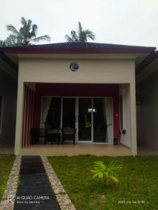 a home with a large glass door with a patio at PONDOK SAHANG COTTAGES in Muntok