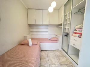 Kleines Zimmer mit 2 Betten und einem Schrank in der Unterkunft Apto a 30m da praia sobre shopping Atlântico in Balneário Camboriú