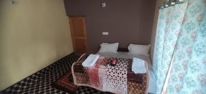uma pequena cama num quarto com uma cortina em Mingoeks Home Stay em Leh