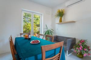 ein Esszimmer mit einem blauen Tisch und einem Obstteller in der Unterkunft Villa Sortis in Pag