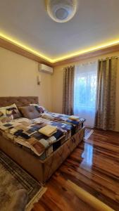 een slaapkamer met een groot bed in een kamer bij Bel Apartman in Subotica