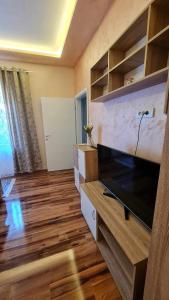 een woonkamer met een grote flatscreen-tv bij Bel Apartman in Subotica