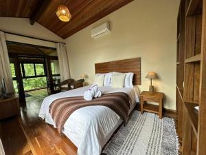 a bedroom with a large bed with a wooden headboard at Pousada A Rosa e o Rei in São Francisco Xavier