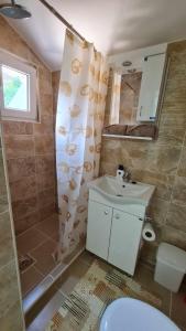 een badkamer met een toilet, een wastafel en een douche bij Bel Apartman in Subotica