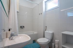 ein weißes Bad mit einem WC und einem Waschbecken in der Unterkunft Villa Sortis in Pag