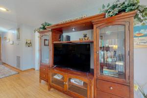 a large wooden entertainment center with a flat screen tv at Flip Flops Inn in Duck