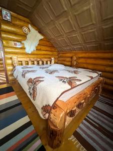 una camera con un letto in una baita di tronchi di Cabana Bradului a Breaza
