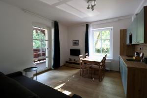 a living room with a table and a kitchen at Apartamenty Dębowa 3 in Polanica-Zdrój