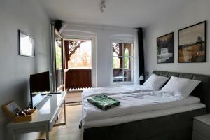 1 dormitorio con cama, escritorio y ventana en Apartamenty Dębowa 3 en Polanica-Zdrój