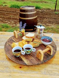 drewniana taca z dwoma filiżankami kawy i chlebem w obiekcie SIMBIOSIS. Agri Cultur'Art Camp w mieście Pontinvrea