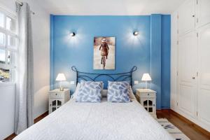 1 dormitorio con paredes azules y 1 cama con 2 mesitas de noche en Apartamento El Zumacal, en Breña Baja