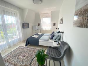 a bedroom with a bed and a chair at Villa Lillybeth - Lake Balaton in Keszthely +70 photos