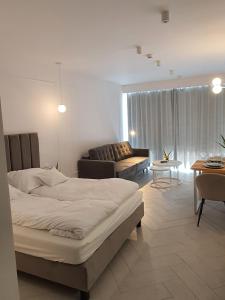 a bedroom with a bed and a living room at Sea & Lake Apartament 17, 317 Molo Mielno Sosnowy Las 15 in Mielno