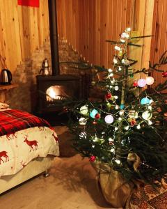 a christmas tree in a room with a fireplace at CENNET DAĞ EVİ in Ayder Yaylasi