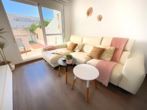 Una sala de estar con un sofá blanco y una mesa. en KS Toyo Golf - Kaleria Suites, en Retamar