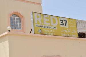 a red sign on the side of a building at Red-37 - Bn Breek Villa in Salalah