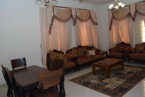 a living room with couches and a table and chairs at Red-37 - Bn Breek Villa in Salalah