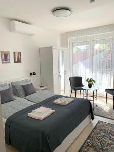 1 dormitorio con 1 cama grande y 2 toallas. en Villa Lillybeth - Lake Balaton, en Keszthely