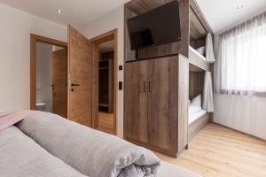 a bedroom with a bunk bed with a flat screen tv at Bergmadl Apartments in Neustift im Stubaital