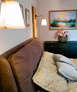 - un canapé dans une chambre avec une lampe et un oreiller dans l'établissement Shine Apartman, à Szentgotthárd