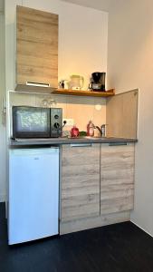 eine kleine Küche mit einer Mikrowelle und einem Kühlschrank in der Unterkunft Happy Studio terrace in Schiltigheim
