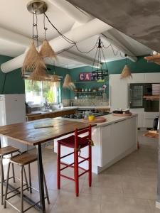 une cuisine avec une grande table et des chaises en bois dans l'établissement La villa Paloma, à Sylvéréal