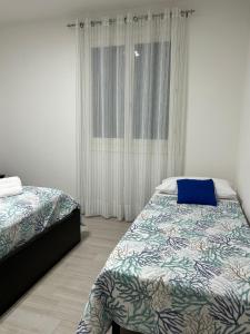 um quarto com 2 camas e uma janela em Casa Anna em Rapolano Terme