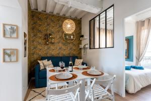 comedor y sala de estar con mesa y sillas en Ulysse - Charmant T2 dans le Centre de Pont-Audemer, en Pont-Audemer