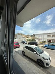 une voiture blanche garée devant une fenêtre dans l'établissement Maddareti trilo, à Milazzo