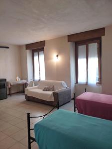 ein Wohnzimmer mit 2 Betten und einem Sofa in der Unterkunft Casa Grazia in Lovero Valtellino