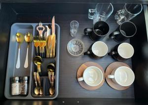 a table with plates and cups and utensils at The Secret Garden Hideaway in Mossel Bay
