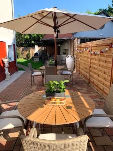 a wooden table with an umbrella on a patio at Villa Lillybeth - Lake Balaton in Keszthely