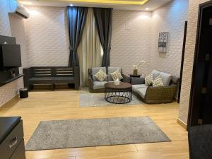 فندق الرياض ان في الرياض: غرفة معيشة مع كنبتين وطاولة