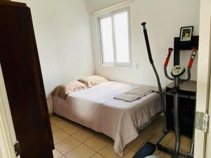 Un dormitorio pequeño con una cama y una ventana. en Casa Ecoamigable, en San Juan Opico