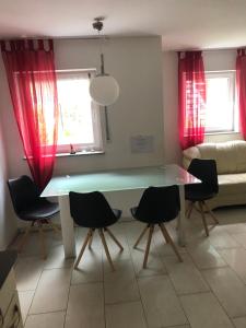 a table and chairs in a living room with red curtains at Apartment Renate Strohhöfer in Hirschaid