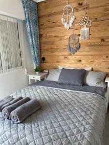 sypialnia z dużym łóżkiem i drewnianą ścianą w obiekcie Przytulny Apartament 100m od plaży w mieście Torrevieja