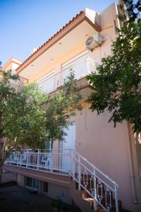 a building with a balcony on the side of it at The Early Bird - Cosy 2-Floor House with Garden in Alexandroupoli