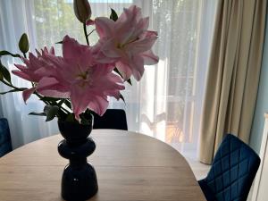 a vase filled with pink flowers sitting on a table at Apartament BARI in Świnoujście