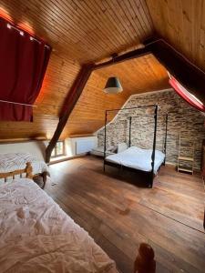 a attic room with two beds and a brick wall at Maison Bretonne de charme à la campagne in Sérent