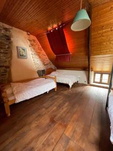 a bedroom with two beds in a wooden cabin at Maison Bretonne de charme à la campagne in Sérent