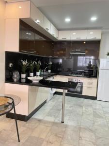 a large kitchen with a black counter and appliances at Studio SvEt 19 in Mohammedia +17 photos