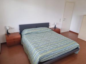 1 cama en un dormitorio con 2 mesitas de noche y 2 lámparas en La Casa di Paolo, Pieve di Cadore centro en Pieve di Cadore