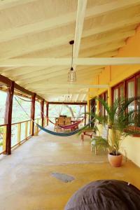 a large room with a hammock in a house at Venao Surf Lodge in Playa Venao