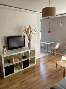 uma sala de estar com uma televisão num armário branco em Happy House em Sopot