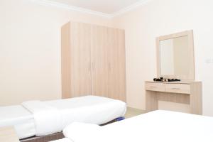 a white room with a bed and a mirror at RED Royal Inn in Salalah