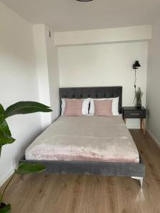 een slaapkamer met een groot bed met roze kussens bij Apartament Rewa House in Rewa