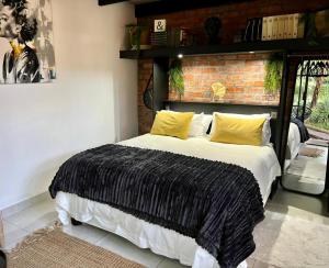 a bedroom with a large bed with a brick wall at The Secret Garden Hideaway in Mossel Bay