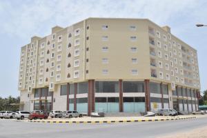 a large building with cars parked in a parking lot at RED Royal Inn in Salalah